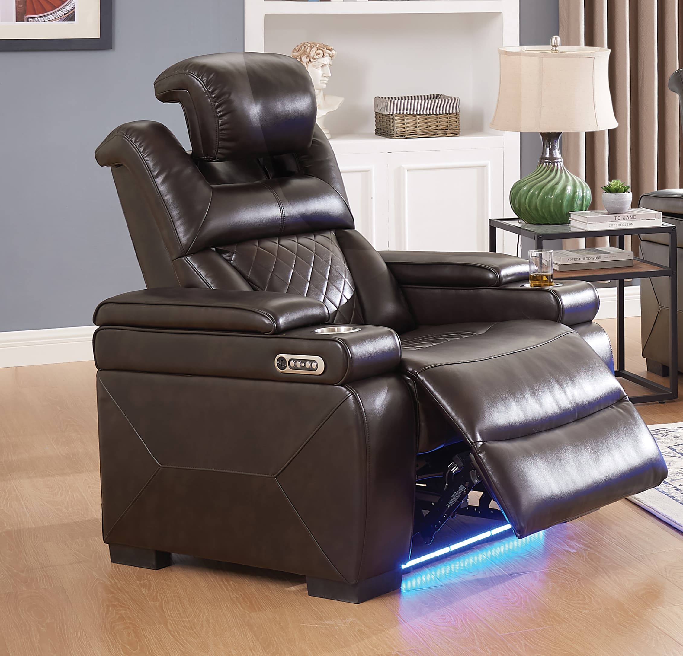 Charcoal Dual Power Recliner with LED & USB — Double power recliner in a brown pu fabric. Quilted stitching pattern on seats and backs. Power headrest and power recline. Blue led theater lighting Dimensions: POWER RECLINER: 38W x 39D x 44H;