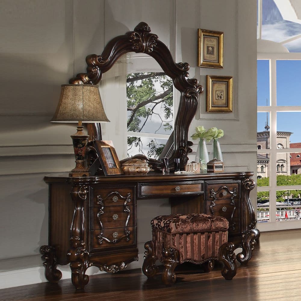 The Versailles vanity stool is the perfect accent to create the style of royalty your bedroom has been needing. This vanity stool crafted in wood with cherry oak finish was inspired by old European design with an upholstered tight seat cushion with welted trim and intricate wood carvings on the scrolled legs.